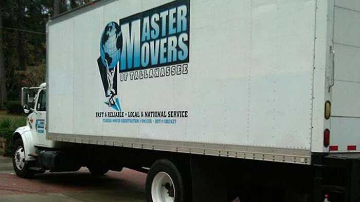 White moving truck with "Master Movers" logo parked outdoors.