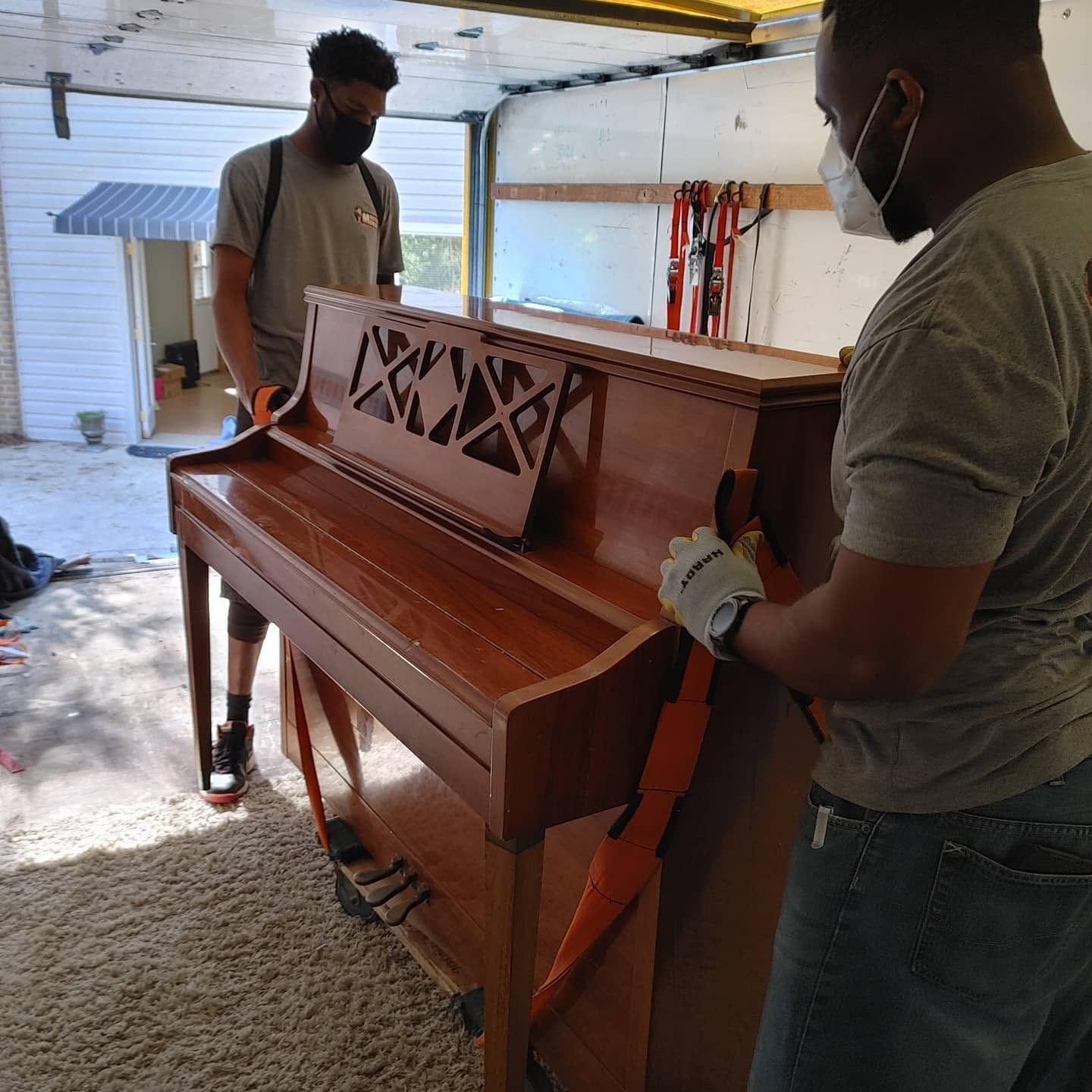 Master Movers of Tallahassee crew strapping an upright piano onto a dolly during a Tallahassee piano move Master Movers of Tallahassee crew strapping an upright piano onto a dolly during a Tallahassee piano move