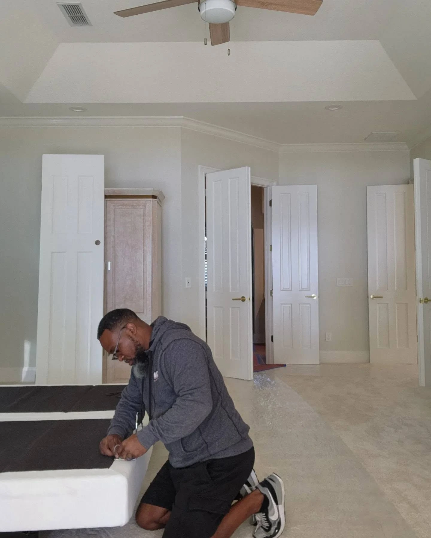 Master Movers of Tallahassee crew member reassembling a bed frame in an empty bedroom after a residential move Master Movers of Tallahassee crew member reassembling a bed frame in an empty bedroom after a residential move